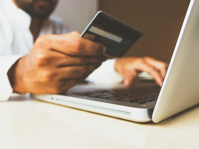 Persona pagando con tarjeta en una tienda online desde su portátil